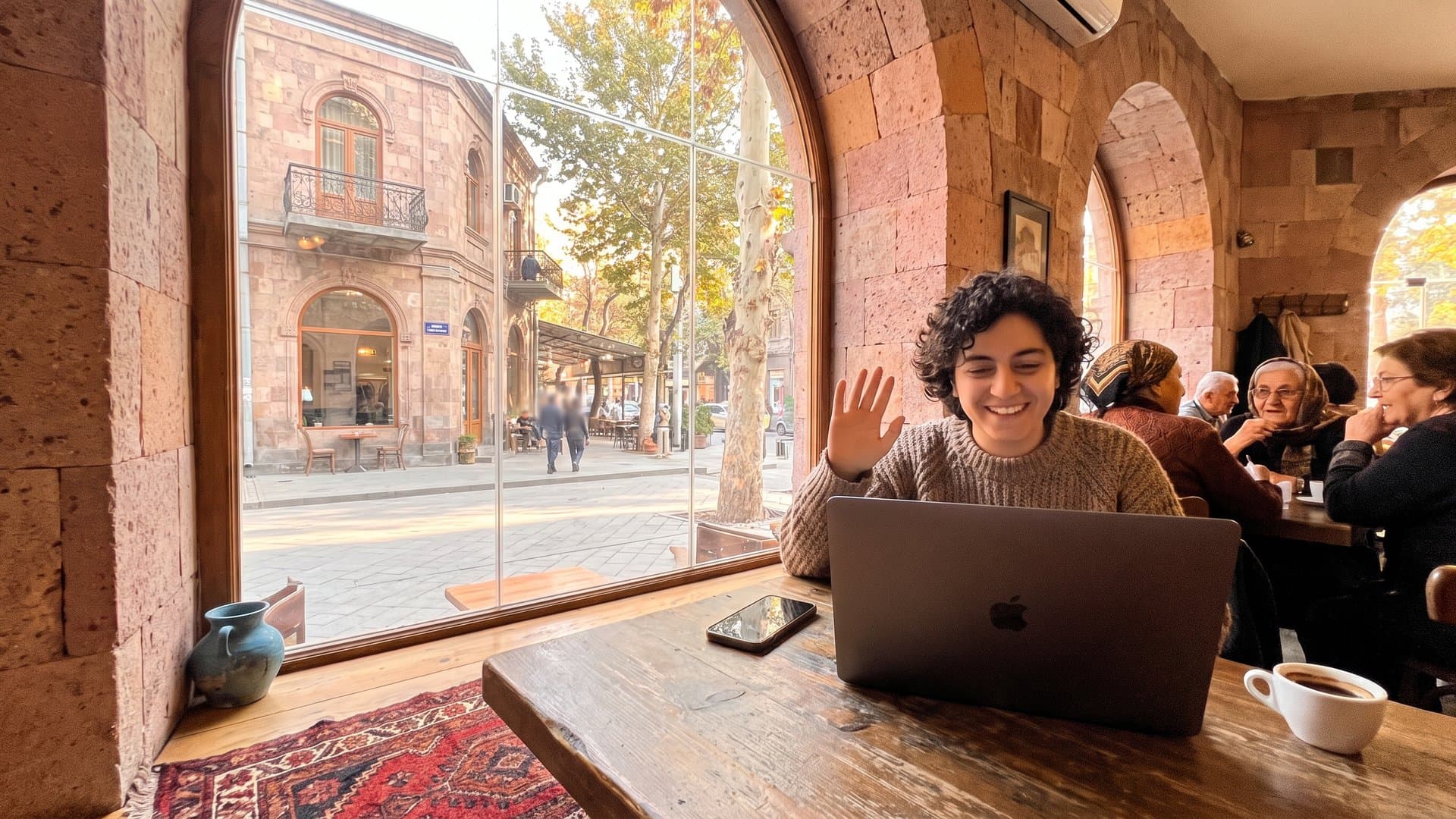 Պատուհանի մոտ սեղան՝ նոութբուքով, հեռախոսով և մի բաժակ սուրճով